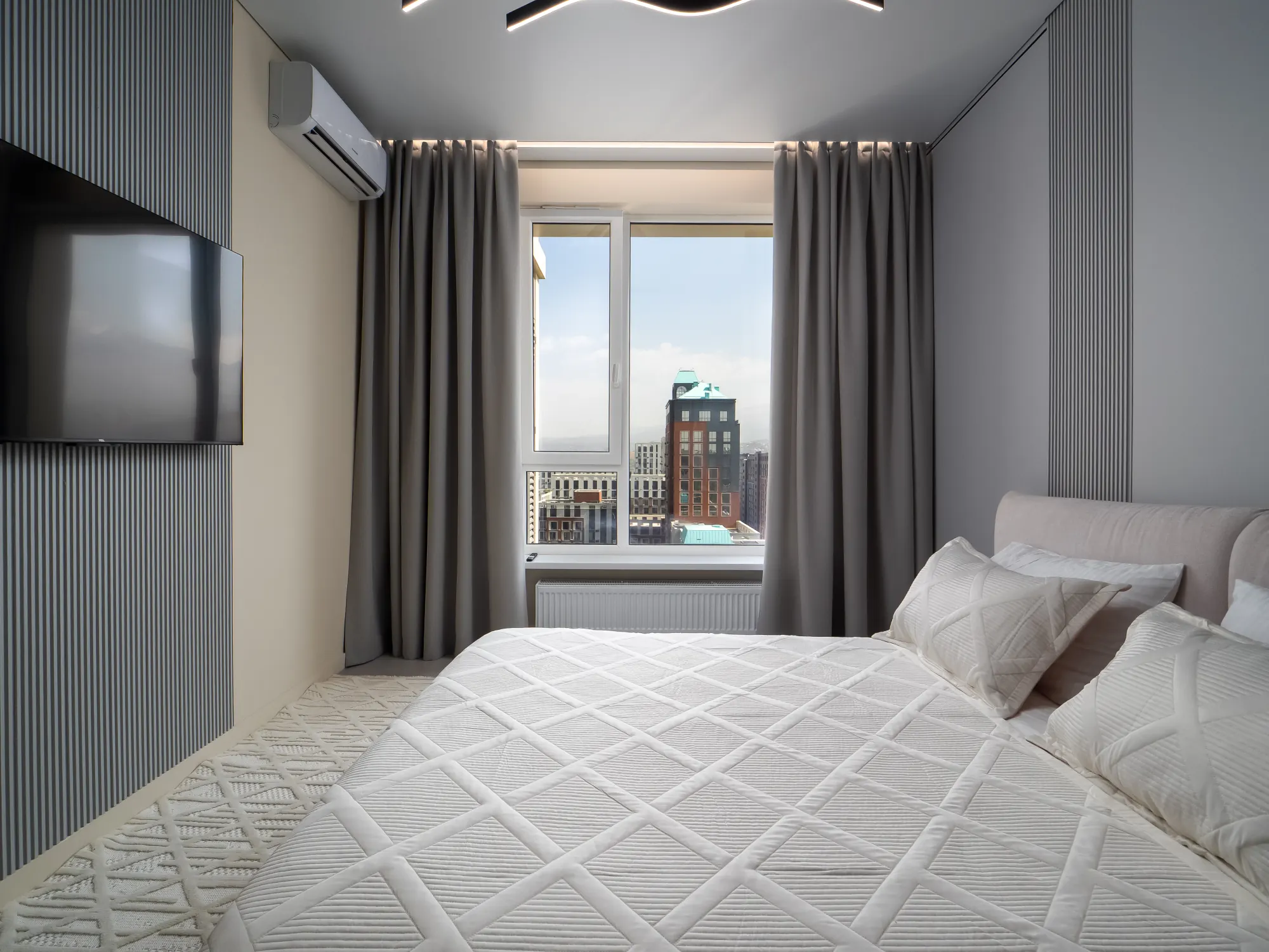 Bedroom with Smart TV and city-facing window